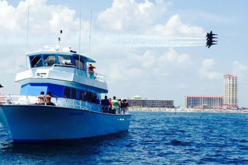 a blue and white boat sitting next to a body of water